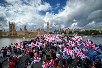 Centenares de personas cruzan el puente de  Westminster junto al Parlamento británico durante la manifestación, este sábado.