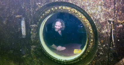 Medical researcher Dr. Joseph Dituri peers out of a large porthole, Saturday, May 13, 2023,