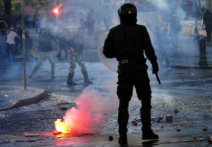 Un antidisturbios trata de contener a los exaltados.