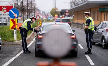 Dos policías piden la documentación al conductor de un vehículo en la frontera entre Alemania-Austria, en Salzburgo. Junto al nuevo confinamiento, el Gobierno austríaco anunció que a partir de febrero la vacuna contra la covid será obligatoria, una medida adoptada ante el bajo índice de inmunización de la población, que es a día de hoy del 66%, insuficiente para frenar la rápida propagación de la variante delta del coronavirus.