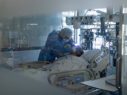 Un sanitario asiste a un enfermo de covid-19 en el interior de la UCI del Hospital Clínic de Barcelona.