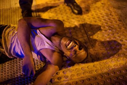 Un migrante africano yace en el suelo exhausto tras cruzar la frontera desde Marruecos a España, en Ceuta, España.