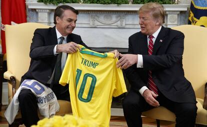 El presidente brasileño, Jair Bolsonaro, entrega a su homólogo estadounidense Donald Trump, una camiseta de fútbol de la selección nacional brasileña con su nombre, en el Despacho Oval de la Casa Blanca, el 19 de marzo de 2019.