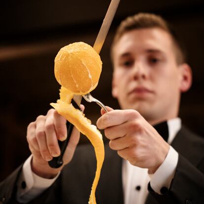 Un profesional de sala pela una naranja al estilo del restaurante Via Veneto, en Barcelona. Imagen proporcionada por el local.