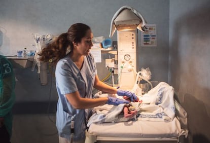 Pieza clave del sistema, el personal sanitario de La Paz lo forman 3.300 empleados. Cerca de 1.700 son enfermeras, y hay unas 50 matronas. En la imagen, una de ellas con un recién nacido en uno de los paritorios de la torre de la Maternidad. Visten uniforme azul.