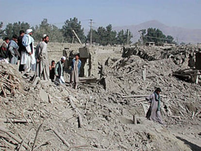 Un grupo de afganos contempla los destrozos producidos por la bomba de EE UU lanzada por error sobre su barrio.