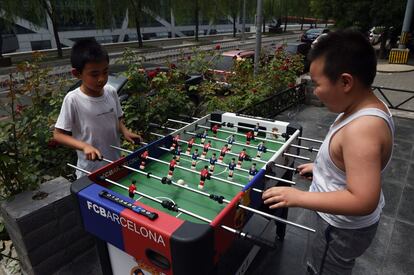 Dos niños chinos juegan al futbolín en Pekín (China).