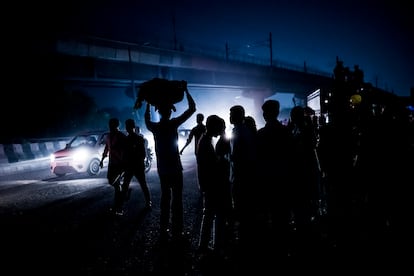 Gente en la carretera en la frontera entre Delhi y Noida después del festival hindú de Chhat puja.