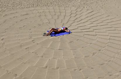 Una mujer toma el sol en una playa en Cannes, Francia.