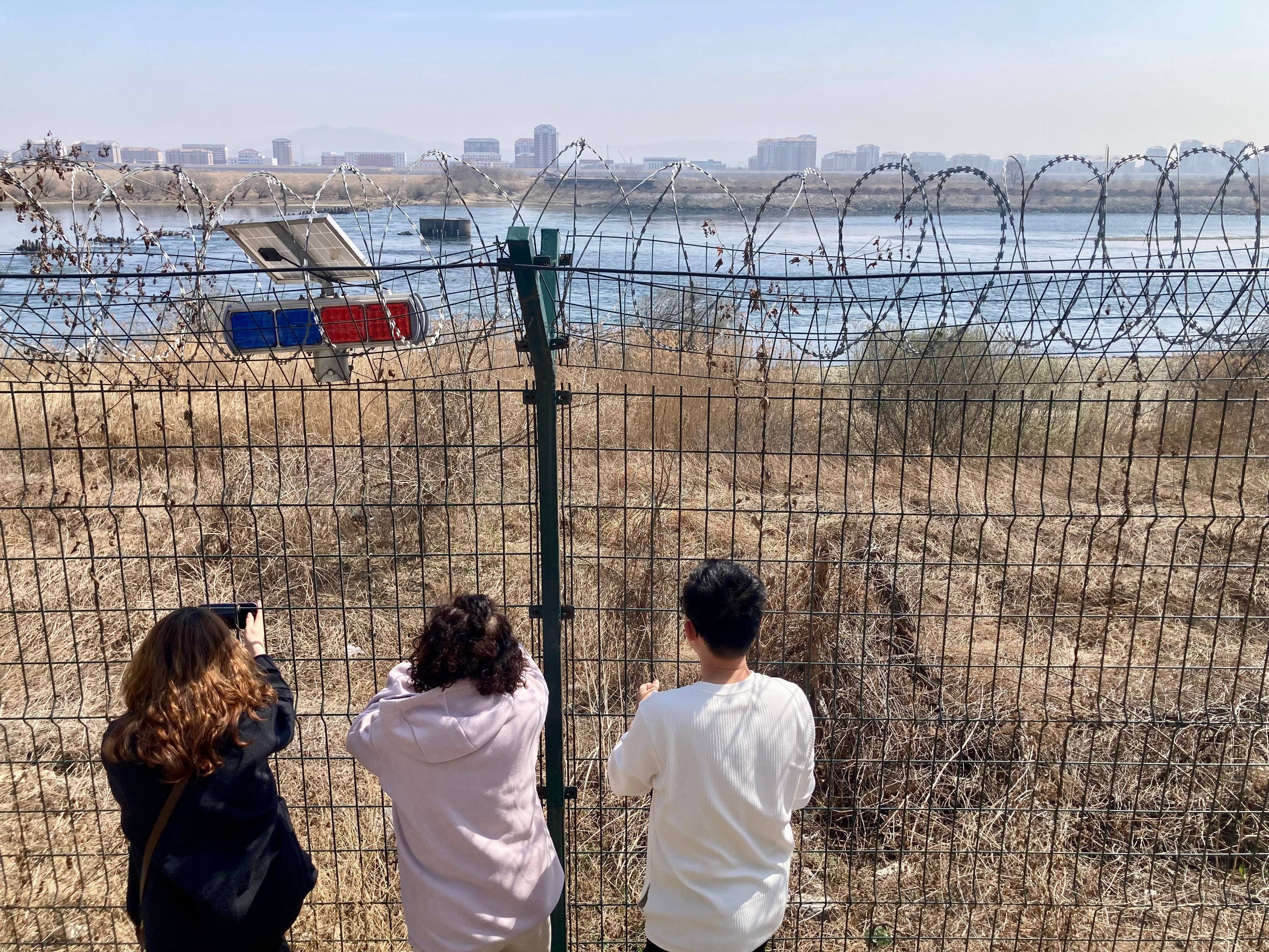 Turistas miran hacia Corea del Norte, al otro lado del río Yalu, cerca de la ciudad china fronteriza de Dandong, el jueves 26 de marzo.