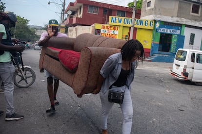 Personas transportan sus pertenencias, este jueves, en Puerto Príncipe.