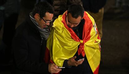 Duas pessoas esperam o resultado das eleições gerais espanholas de 2015.