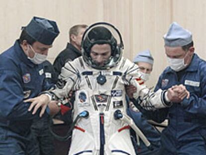 Duque es ayudado a levantarse tras ponerse el traje espacial el pasado sábado.