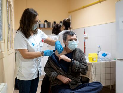Una sanitaria vacuna la dosis de refuerzo contra la covid a un usuario de la Fundació Arrels en Barcelona.