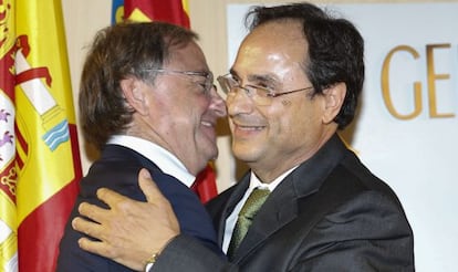 El consejero saliente Juan Carlos Moragues abraza al nuevo consejero de Hacienda, Vicent Soler.