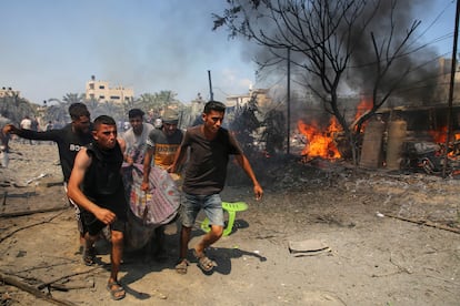 Varias personas trasladan a un herido tras el bombardeo israelí en Al Mawasi, este sábado. 