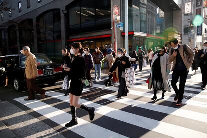 Viandantes cruzan una calle en la zona comercial de Ginza, en Japón.