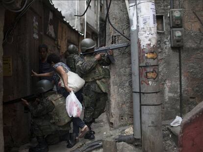 Moradora entra em viela durante incursão policial na favela da Rocinha, no Rio de Janeiro.