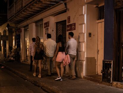 Tourists walk with local women in the historic center of Cartagena, February 22, 2024.