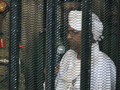 Al Bashir asiste ebtre rejas a una vista judicial en Jartum el pasado diciembre.