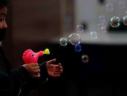 Una niña juega con una pistola de burbujas regalada por el personal de Migración luego de ser deportada con su familia desde Texas a Ciudad de Guatemala (Guatemala).