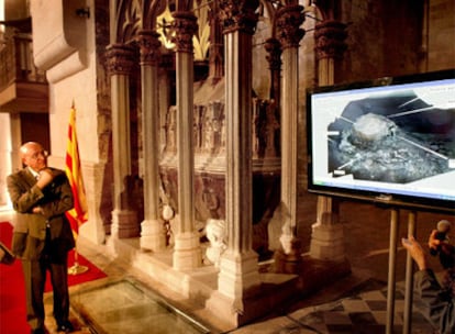 El consejero Tresserras en Santes Creus, junto a la tumba del rey Pere el Gran y la imagen que muestra su momia.