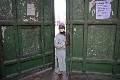 Un hombre abre la puerta de una mezquita durante el mes sagrado del Ramadán en los barrios antiguos de Nueva Delhi (India).