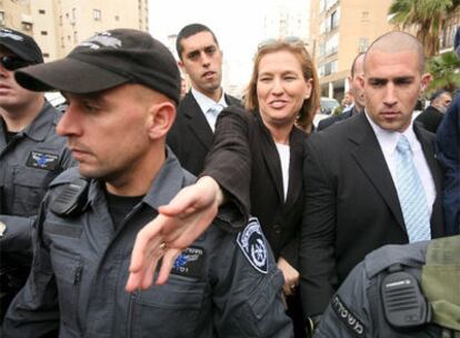 La presidenta del Kadima, Tzipi Livni, saluda antes de depositar su voto en Tel Aviv.