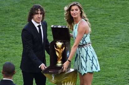 El defensa español Carles Puyol y la modelo brasileña Gisele Bundchen posan con la Copa del Mundo durante la ceremonia de clausura.