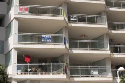 Edificio de apartamentos de Marina d'Or esta semana con varios carteles de se vende.
