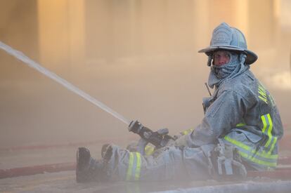 Un bombero, cubierto de hielo, trabaja para apagar un incendio en Ann Arbor, Míchigan.