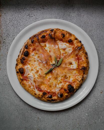 Pizza con cebolleta y tomate de la huerta del restaurante, con 'guanciale' de elaboración propia de su ganadería de bellota propia.