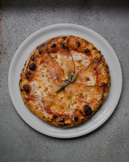 Pizza con cebolleta y tomate de la huerta del restaurante, con 'guanciale' de elaboración propia de su ganadería de bellota propia.