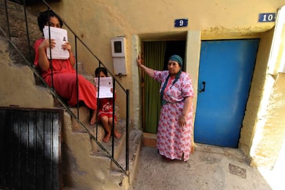 Dos niñas muestran las solicitudes de inscripción escolar en su casa del barrio melillense de La Cañada, junto a su abuela.