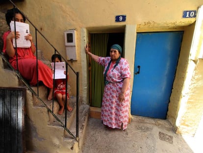 Dos niñas muestran las solicitudes de inscripción escolar en su casa del barrio melillense de La Cañada, junto a su abuela.