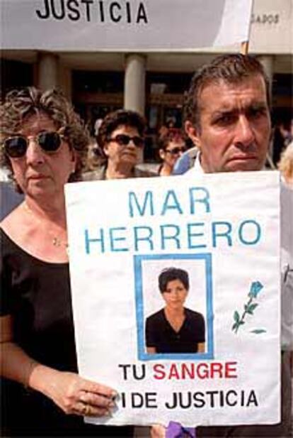 Los padres de Mar Herrero sostienen una pancarta con la foto de su hija.