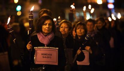 Un grupo de mujeres porta 77 antorchas y esquelas en recuerdo de las v&iacute;ctimas de violencia de g&eacute;nero en 2013 en Espa&ntilde;a.