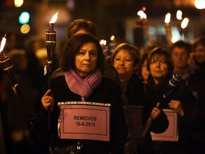 Un grupo de mujeres porta 77 antorchas y esquelas en recuerdo de las v&iacute;ctimas de violencia de g&eacute;nero en 2013 en Espa&ntilde;a.