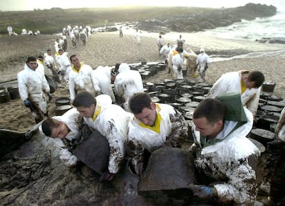 Catástrofe ecológica en Galicia por la marea negra causada por el hundimiento del petrolero Prestige cargado de fuel oil, frente a sus costas. En la foto, soldados de la Brigada Guzmán el Bueno de Córdoba , forman una cadena para la limpieza del chapapote en una playa de Lira (A Coruña) el 24 de diciembre de 2002.