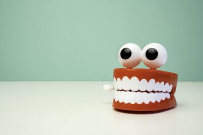 Dentures And Goggly Eyes On Table Against Wall