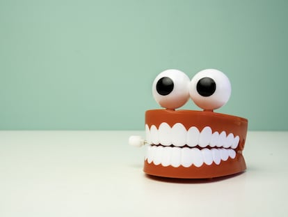 Dentures And Goggly Eyes On Table Against Wall