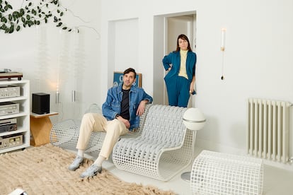 Imanol Calderón y Marta Alonso, en el salón de su casa-estudio en Madrid. Viven rodeados de sus piezas y prototipos: las butacas de aluminio Buit Gradient para Gandia Blasco; las lámparas verticales Filamento (izda.) y, en la pared, el aplique Hi (fuego en japonés).