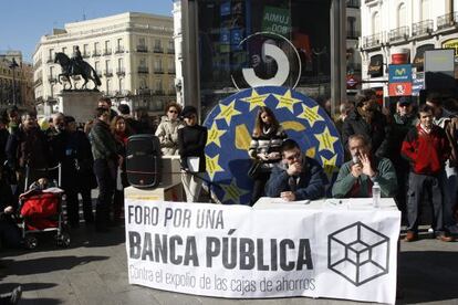 Los dos ponentes explican en la Puerta del Sol las ventajas de una banca pública.