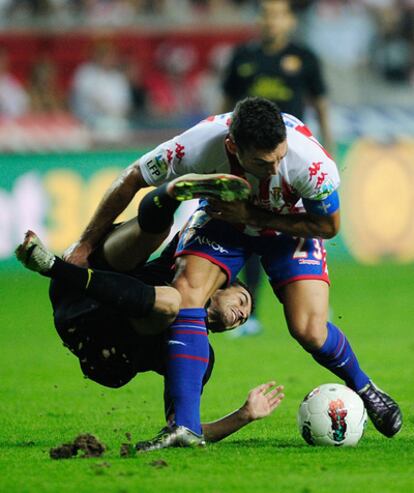 Pedro choca con Barral en la pugna por el balón.