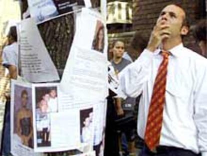 Louis Drogin lee información sobre desaparecidos junto al edificio donde se coordinan los datos.