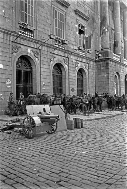 Soldats davant l'edifici de l'Ajuntament de Barcelona, on es poden veure els impactes de l'artilleria durant el Sis d'Octubre.