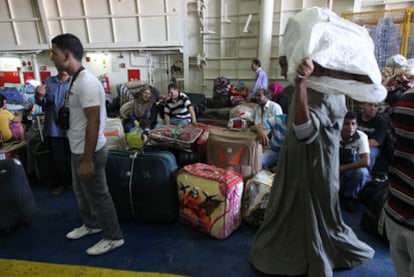 Refugiados, en su mayoría egipcios, embarcan con destino a Bengasi, ayer en el puerto de Trípoli.