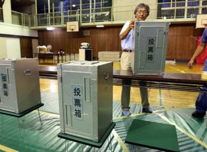 Funcionarios de la comisión electoral preparan las urnas en un colegio de Tokio para los comicios del domingo.