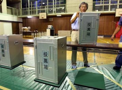 Funcionarios de la comisión electoral preparan las urnas en un colegio de Tokio para los comicios del domingo.