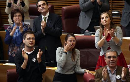 Diputados de Compromís y del PSPV aplauden a los miembros del comité de empresa de RTVV que gritan desde el balcón de invitados a los miembros del PP. En el centro de la imagen, la diputada de Compromís, Mireia Mollá, llora tras conocer el resultado de la votación.
